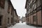 An old street with abandoned houses. Snowy cloudy day.