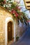 Old street along beautiful stone houses adorned with coloured blooming trees in small village in mountains of Lefkara, Cyprus.