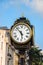 Old Street Clock In Europe. Clock Face With Roman Numerals And Arrows, Cast-iron Column And Gold Decorative Elements