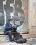 Old street musician playing recorder instrument for money in front of grunge graffiti, Istiklal street, Istanbul, Turkey