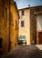 Old street in San quirico d`orcia Italy with old piaggio car