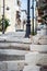 Old street with stony steps and sitting cat at Sitian town in eastern part of Crete island