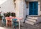 Old streets and houses of Marmaris. Table with colorful chairs blue, pink, white stands near entrance to the house with blue eas