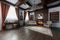 Old studying room with fabric armchairs and wooden table. Classic bookcase filled with books. Fireplace