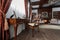 Old studying room with fabric armchairs and wooden table. Classic bookcase filled with books. Fireplace