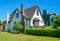 Old style family house with lawn and hedgerow in front on blue sky background