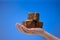 Old style homemade artisanal soap bars held in male palm. Close up studio shot, isolated on blue background