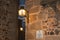 Old style metal sconce stuck to the stone wall and soft light at dusk in Caceres