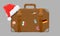 Old style vintage brown voyage suitcase with travel stickers and christmas or santa claus hat or cap. Vector