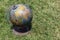 Old Style World Globe written in Bengali language - Antique world globe on grass filed background. Showing India