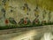 Old style worn out wall with oriental colorful decoration as a wallpaper background texture pattern with dimmed lights interior