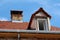 Old suburban family house under reconstruction with new roof window and roof tiles already installed surrounded with shiny gutter