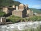 Old Svan village stone house in Svaneti, standing on the bank of the fast river. Ushguli. Caucasus. Georgia.