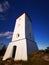 Old swedish lighthouse with red roof with blue sky as background. Built in 1777