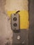 Old switch on the grey and yellow concrete wall in studio of building