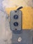 Old switch on the grey and yellow concrete wall in studio of building