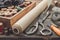 Old tailoring scissors, measuring tape, thimble, vintage spools of thread in wooden box, patterns on paper and cutting knife.