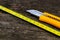 Old tape measurer  yellow utility knife on aged weatherd wood boards