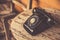 Old telephone black color on wood table. classic retro vintage style