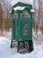 Old telephone box in forest under snow