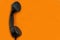 Old telephone handset close up on orange background