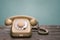 Old telephone stands on the wooden boards isolated on a blue background