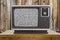 Old Television with Static Screen and Rustic Wood Wall