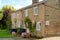 Old terraced cottages seen with celebration bunting outside together with table and chairs.