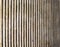 Old textured cast concrete wall with vertical lines and striped design