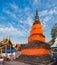 Old Thai Buddhist pagoda wrapped with orange robes