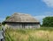 Old thatched double door barn In a field