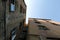 Old threadbare dwelling house wall view from inner yard bottom up under clear blue sky