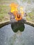 old thrown away shoes on flame by the edge of the cylindrical concrete well.