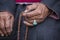 Old Tibetan woman holding buddhist rosary in Hemis monastery, Ladakh, India. Hand, turquoise ring and rosary, close up