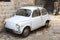 Old-timer white small italian car parked in an all