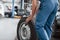 Old tire. Employee in the blue colored uniform works in the automobile salon