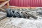 Old tires lie on the snow next to a stone fence and a wooden arbor