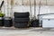 Old tires and old wheels piled up at a corner of a garage.