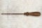 Old tool screwdriver with wooden handle isolated