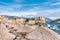 The old town of Budva. The Beach Of Budva. Umbrellas on the beach in the foreground. Clear Sunny day, blue sky over the