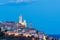 The old town of Cervo, Liguria, Italy, with the beautiful baroque church and tower bells arising from the colorful houses, illumin