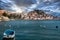 Old town of Sibenik, Croatia seen from a distant beach. Small old blue ship anchored. Mediterranean typical traditional seascape