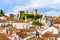 Old town skyline of Obidos, Portugal with house roof tops, church towers and the wall of the medieval castle located in the civil