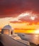 Old Town of Thira on the island Santorini, white church against colorful sunset in Greece