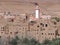 Old town of Tinghir with minaret, green palm oasis and rocky Atlas Mountains range landscape in southeastern Morocco