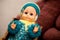 Old toy is a vintage doll with blue eyes in a woolen hat. Item from the past