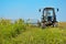 Old tractor mowing corn in the field closeup