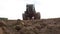 Old tractor plowing field, preparing land for sowing, driving over the camera at sunset, bottom