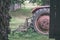 old tractor with rubber tires in green countryside yard in green summer - vintage retro film look