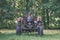 old tractor with rubber tires in green countryside yard in green summer - vintage retro film look